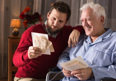 Caregiver reading to elderly man